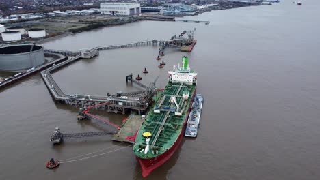 Silver-Rotterdam-oil-petrochemical-shipping-tanker-loading-at-Tranmere-terminal-Liverpool-aerial-view-tilt-up-left-orbit