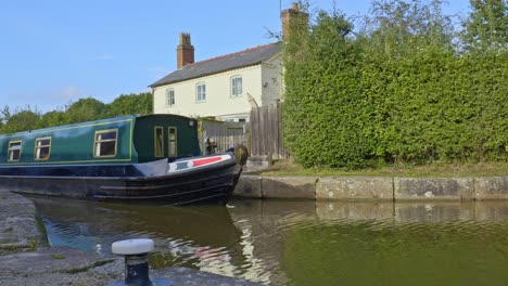 Green-hired-narrowboat-with-group-of-happy-male-friends-cruise-through-lock-system-on-Shropshire-Union-canal