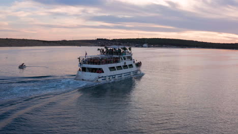 Barco-De-Fiesta-Lleno-De-Gente-Navegando-En-Una-Puesta-De-Sol-En-Novalja,-Isla-De-Pag,-Croacia