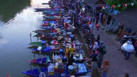 Tiro-De-ángulo-Alto-Sobre-El-Mercado-Flotante-De-Khlong-Hae-Con-La-Comunidad-Local-Que-Vende-Comida-Local-A-Turistas-Y-Lugareños-En-La-Provincia-De-Songkhla,-Tailandia-Durante-La-Noche