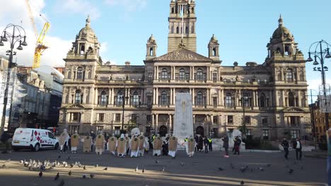 Gente-Caminando-Frente-A-Una-Protesta-Por-El-Cambio-Climático-En-George-Square,-Glasgow