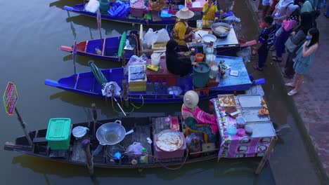 High-angle-shot-over-local-sellers-selling-local-cuisine-in-Khlong-Hae-Floating-Market-in-Songkhla-province,-Thailand-during-evening-time