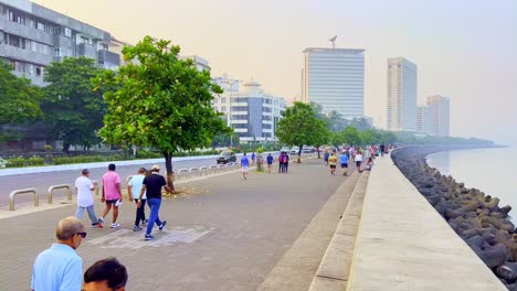 Ein-Blick-Auf-Menschen,-Die-Morgens-Die-Strandstraße-Entlang-Spazieren-Gehen