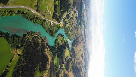 Pure-blue-river-and-majestic-New-Zealand-landscape,-aerial-drone-vertical-video