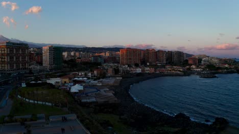 Aerial-Flying-Over-Bunker-Stazione-Zona-Europa-In-Catania-With-View-Of-Beach-Coastline-During-Sunset