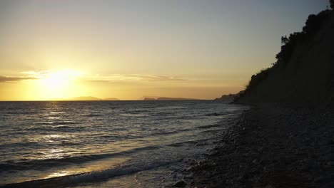 Zeitlupenschwenk-über-Die-Atemberaubende-Küste-Bei-Sonnenuntergang-In-Arillas,-Korfu,-Griechenland