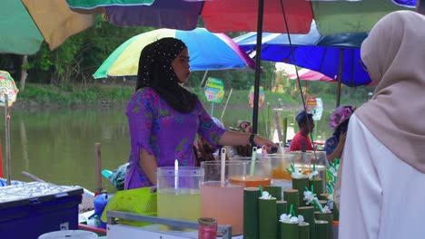 Statische-Ansicht-Einer-Thailändischen-Jungen-Frau,-Die-Säfte-In-Den-Ufern-Des-Schwimmenden-Marktes-Von-Kong-Hae-Verkauft