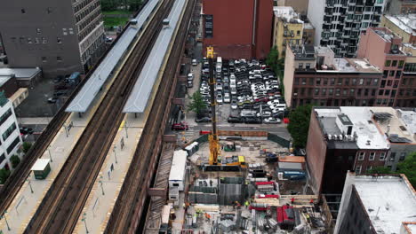 Aerial-view-of-a-construction-site-close-to-a-railway-station-in-Harlem,-NYC,-USA