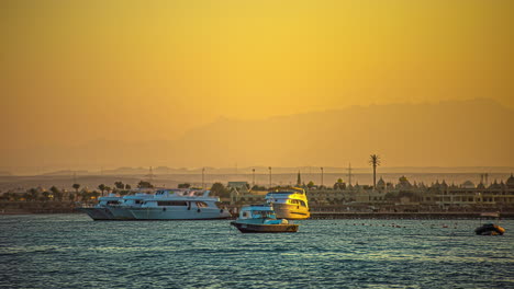 Hazy-golden-sunset-with-boats-in-the-Red-Sea-harbor---time-lapse
