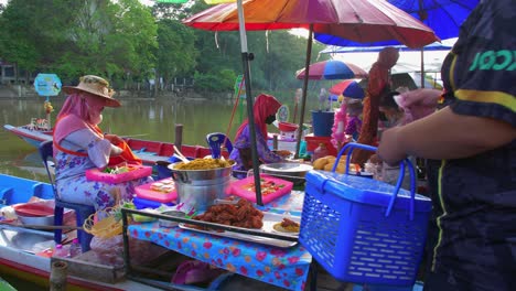Thailändische-Arbeiterin,-Die-Lokales-Asiatisches-Essen-Von-Einem-Boot-An-Den-Ufern-Eines-Schwimmenden-Marktes-Verkauft