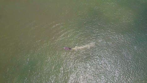 Victoria-Island-Lagos,-Nigeria---20-November-2022:-Drone-view-of-a-fisherman-on-a-fishing-boat-on-the-coastline-of-Lagos