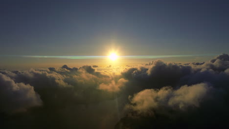 Aerial-drone-shot-of-golden-sunrise-with-anamorphic-lens-flare-above-cloudscape-in-the-morning