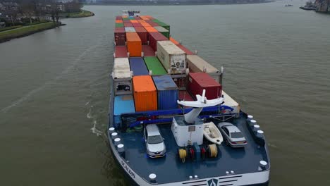 29-January-2023---Aerial-Overhead-Circle-Dolly-Around-Forward-Bow-Of-Scaldis-Container-Ship-Travelling-Along-River-On-Overcast-Day-In-Dordrecht