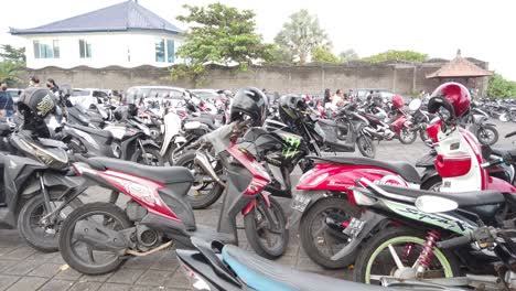 Vintage-motorcycle-and-scooter-parking-on-Purnama-beach-in-Bali,-Indonesia,-colorful-motorbikes-and-helmets