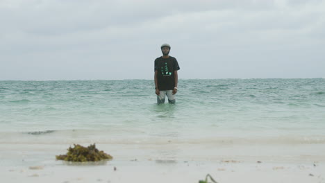Slow-motion-shot-of-a-handsome-young-black-man-in-the-ocean-water-looking-at-the-camera