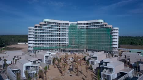 Beach-resort-or-residential-development-under-construction-from-aerial-orbit-view-including-villas-and-swimming-pool-on-a-sunny-day