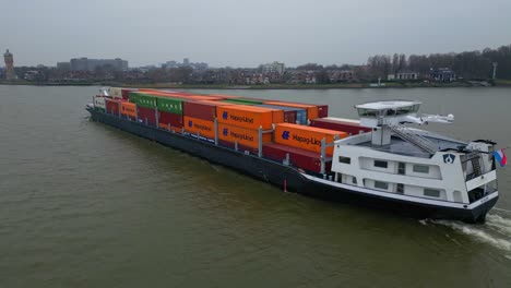 Vista-Aérea-Del-Lado-Del-Puerto-Del-Buque-Portacontenedores-Scaldis-Que-Viaja-A-Lo-Largo-De-Oude-Maas-En-Un-Día-Nublado-En-Dordrecht