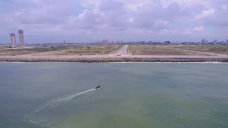 Victoria-Island-Lagos,-Nigeria---20-November-2022:-Drone-view-of-a-fisherman-on-a-fishing-boat-on-the-coastline-of-Lagos