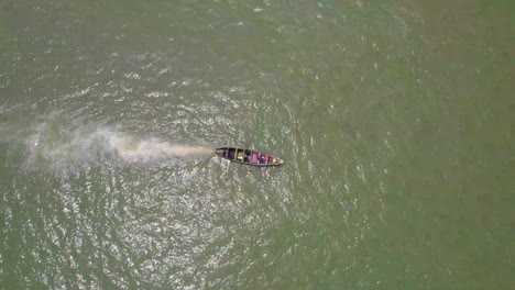 Victoria-Island-Lagos,-Nigeria---20-November-2022:-Drone-view-of-a-fisherman-on-a-fishing-boat-on-the-coastline-of-Lagos