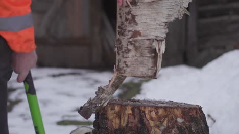 Ein-älterer-Mann-In-Den-Sechzigern-Hackt-Holz-Mit-Einer-Axt-Während-Des-Europäischen-Winters-4k-Clip-1