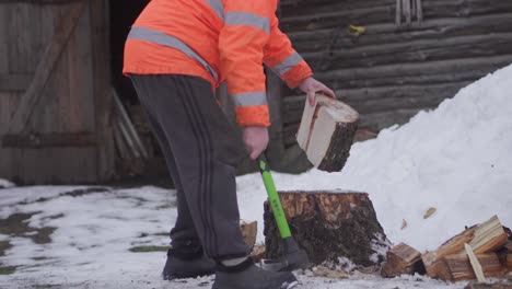 Un-Anciano-De-Unos-Sesenta-Años-Está-Cortando-Leña-Con-Un-Hacha-Durante-El-Invierno-Europeo-4k-Clip-1