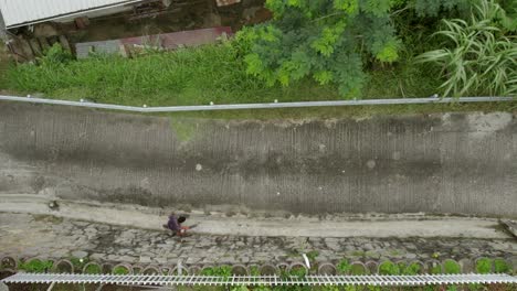 Hombre-Limpiando-La-Carretera-Con-Soplador-De-Aire-En-Un-Pequeño-Pueblo-En-Beau-Vallon,-Mahe,-Seychelles