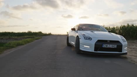 Reveal-white-Nissan-GTR-sport-car-drive-empty-countryside-road