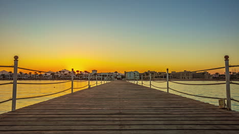 Looking-along-a-wooden-dock-or-pier-on-the-Red-Sea-in-Egypt-at-sunset---time-lapse