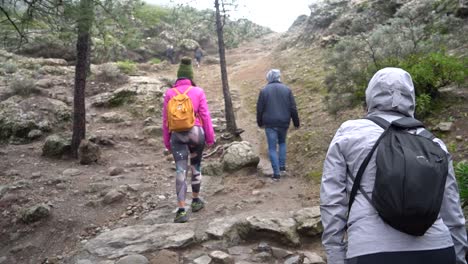 Las-Palmas-de-Gran-Canaria,-Spain---January-24,-2023:-Hiking-group-ascending-to-Roque-Nublo-duroing-a-misty-morning-in-Gran-Canary-Island,-Spain