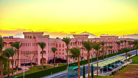 Vehicles-driving-along-a-street-during-a-sunset-time-lapse-in-Hurghada,-Egypt