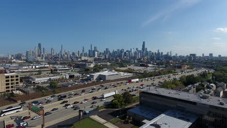 Chicago-Il-Usa,-Vista-Aérea-Del-Ajetreado-Tráfico-Diario-En-La-Autopista-I-90-Con-Rascacielos-Del-Centro-En-Segundo-Plano