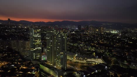 Vista-Aérea-Lejos-Del-Complejo-Comercial-Arcos-Bosques,-Anochecer-En-La-Ciudad-De-México---Retroceder,-Tiro-De-Drones