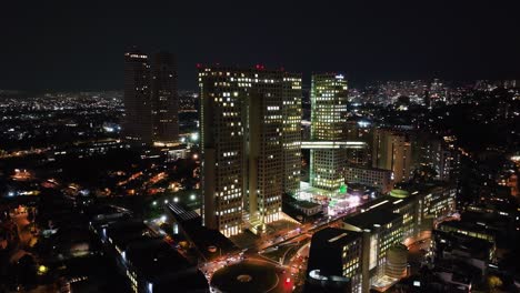 Vista-Aérea-Alrededor-Del-Complejo-Comercial-Arcos-Bosques-Iluminado,-Noche-En-La-Ciudad-De-México