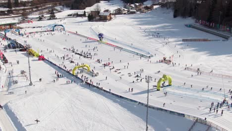 Aerial-orbiting-shot-of-skiers-in-Val-di-Fiemme-Italy