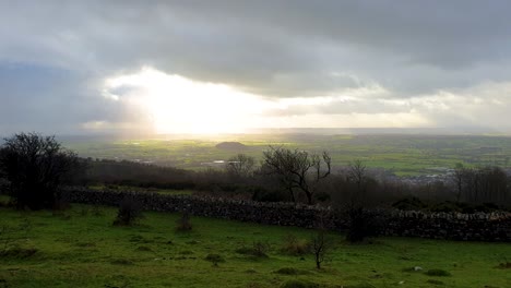 Sunlight-shining-through-rain-clouds-over-rural-English-countryside-landscape-view-from-Cheddar-Gorge-in-Sedgemoor-district-of-West-Country-in-Somerset,-England