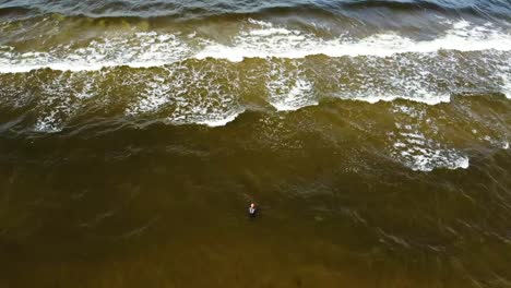 Vista-De-Video-De-Drones-Desde-Arriba-Una-Mujer-Camina-Hacia-El-Mar