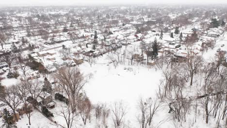 Aerial,-rural-suburb-neighborhood-in-America-covered-in-snow-during-winter