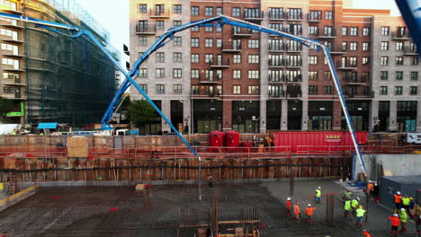 Aerial-view-under-concrete-pumps-while-people-work-on-a-construction-first-floor