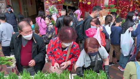 Chinesische-Käufer-Kaufen-Dekorative-Chinesische-Neujahrsthemenblumen-Und-Pflanzen-An-Einem-Blumenmarkt-straßenstand-Vor-Den-Chinesischen-Neujahrsfestlichkeiten-Nach-Dem-Mond