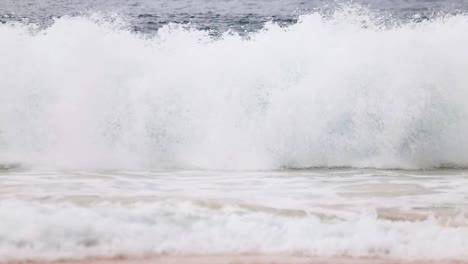 Beach-goers-perspective-of-man-in-water-taking-pictures-of-large-crashing-shorebreak-waves-on-Sandy-Beach,-Oahu,-Hawaii