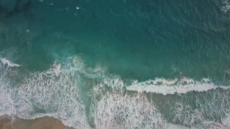 Brechende-Wellen-An-Einem-Sandstrand-Aus-Einer-Absteigenden-Luftperspektive-Mit-Einer-Leichten-Neigung-Nach-Oben
