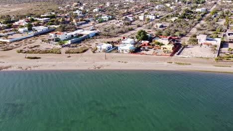 A-wide-reaching-aerial-shot-of-the-town-and-sea-of-La-Paz,-Baja-California-Sur,-Mexico,-taken-from-a-drone-flying-away-from-the-scene