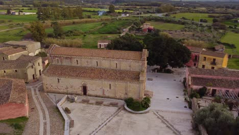 Stunning-aerial-drone-of-church-of-old-Tratalias-in-South-Sardinia,-circle-pan
