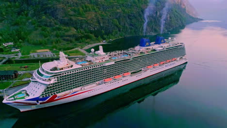 Fotografía-Aérea-De-Un-Crucero-Gigante-En-El-Puerto-De-Flam-Con-Humo-Ascendente-De-Pilas-En-Noruega,-Europa