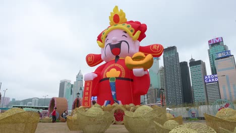 A-man-walks-across-the-frame-in-front-of-a-Chinese-New-Year-theme-installation-event-for-the-Chinese-Lunar-New-Year-as-skyscrapers-are-seen-in-the-background-in-Hong-Kong