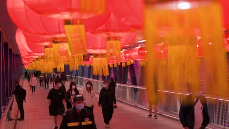 Pendler-Gehen-Durch-Eine-Fußgängerbrücke,-Die-Mit-Chinesischen-Roten-Laternen-Geschmückt-Ist,-Die-Von-Der-Decke-Hängen,-Um-Das-Chinesische-Neujahrsfest-In-Hongkong-Zu-Feiern