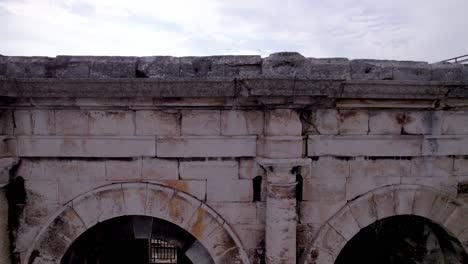Sehr-Enge-Luftaufnahme-Der-Gewölbe-Und-Steine-Der-Arenen-Von-Nîmes,-Die-Sich-Erheben,-Um-Das-Innere-Zu-Enthüllen-Und-Die-Tribünen-Zu-Sehen