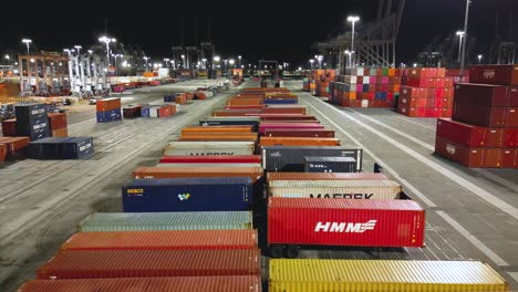 shipyard-in-Long-Beach-at-night-in-this-drone-aerial-view,-showcasing-towering-cranes-and-rows-of-cargo-containers-at-night