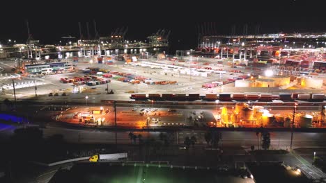 Drohnenansicht-Der-Long-Beach-Shipyard-Bei-Nacht-Mit-Hoch-Aufragenden-Kränen-Und-Reihen-Von-Frachtcontainern