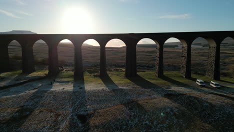 Railway-bridge-archway-fly-through-at-sunset-in-winter-over-moorland-at-Ribblehead-Viaduct